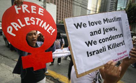 Filipino women hold placards during a protest against Israeli attack on the Gaza Strip, near the Israeli Embassy in Manila, capital of the Philippines, Jan. 14, 2009. [Luis Liwanag/Xinhua]