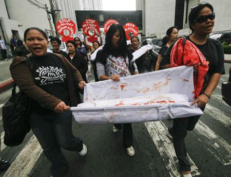  Filipino women hold a mock dead baby during a protest against Israeli attack on the Gaza Strip, near the Israeli Embassy in Manila, capital of the Philippines, Jan. 14, 2009. [Luis Liwanag/Xinhua] 