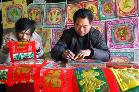 Villagers make traditional decoration for doors presenting good wishes in Tancheng County, east China's Shandong Province, Jan. 13, 2009, to welcome the forthcoming Chinese traditional Spring Festival, which falls on Jan. 26 this year.[Xinhua]