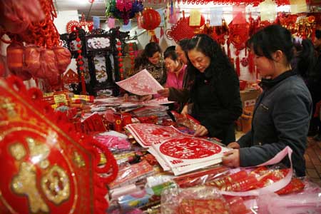 People select paper-cut decorations at a market in Guiyang, capital of southwest China's Guizhou Province, Jan. 13, 2009. People were busy in selecting all kinds of decorations and goods to greet the Chinese traditional Spring Festival, which falls on Jan. 26 this year.[Xinhua]