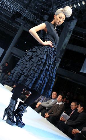  A model displays costumes during an environment-friendly fashion show in east China's Shanghai, Jan. 14, 2009. [Liu Ying/Xinhua]