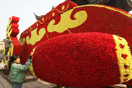 Workers arrange flowers-weaved Chinese character of 'chun' (meaning 'spring') and drum-shaped flower sculpture on the Ganjiang Road in Suzhou, east China's Jiangsu Province, Jan. 14, 2009. As the Year of Ox in Chinese lunar calendar approaching, the city is permeated with a holiday atmosphere. The Chinese Year of Ox will start from Jan. 26, 2009. [Hang Xingwei/Xinhua] 