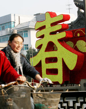 The flowers-weaved Chinese character of 'chun' (meaning 'spring') is seen on the Ganjiang Road in Suzhou, east China's Jiangsu Province, Jan. 14, 2009. As the Year of Ox in Chinese lunar calendar approaching, the city is permeated with a holiday atmosphere. The Chinese Year of Ox will start from Jan. 26, 2009. [Hang Xingwei/Xinhua] 