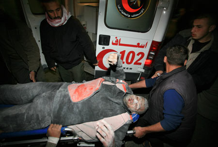 Palestinian medics send a wounded man of the Civil Defense, who was hurt in an Israeli strike, to Shifa hospital in Gaza City, Jan. 14, 2009. Gaza emergency chief Mo'aweya Hassanein said on Wednesday night that the Israeli army killed on Wednesday 28 Palestinians and wounded 80 others. [Wissam Nassar/Xinhua]