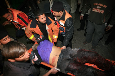 Palestinian medics send a wounded man of the Civil Defense, who was hurt in an Israeli strike, to Shifa hospital in Gaza City, Jan. 14, 2009. Gaza emergency chief Mo'aweya Hassanein said on Wednesday night that the Israeli army killed on Wednesday 28 Palestinians and wounded 80 others. [Wissam Nassar/Xinhua]