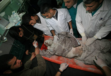 Palestinian medics send a wounded man of the Civil Defense, who was hurt in an Israeli strike, to Shifa hospital in Gaza City, Jan. 14, 2009. Gaza emergency chief Mo'aweya Hassanein said on Wednesday night that the Israeli army killed on Wednesday 28 Palestinians and wounded 80 others. [Wissam Nassar/Xinhua]