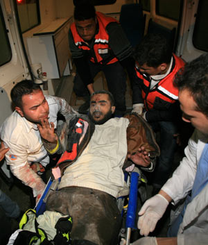 Palestinian medics send a wounded man of the Civil Defense, who was hurt in an Israeli strike, to Shifa hospital in Gaza City, Jan. 14, 2009. Gaza emergency chief Mo'aweya Hassanein said on Wednesday night that the Israeli army killed on Wednesday 28 Palestinians and wounded 80 others. [Wissam Nassar/Xinhua]