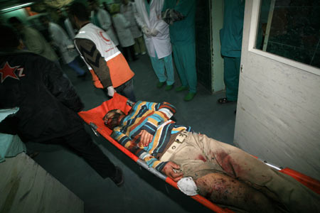  Palestinian medics send a wounded man of the Civil Defense, who was hurt in an Israeli strike, to Shifa hospital in Gaza City, Jan. 14, 2009. Gaza emergency chief Mo'aweya Hassanein said on Wednesday night that the Israeli army killed on Wednesday 28 Palestinians and wounded 80 others. [Wissam Nassar/Xinhua]