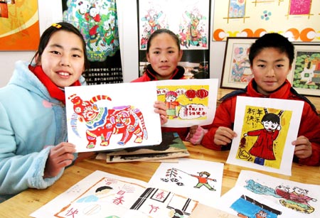 Pupils shows their handmade Taohuawu woodcut New Year paintings in Taowu Central Elementary School in Suzhou, east China&apos;s Jiangsu Province, Jan. 14, 2009. An activity with the theme of greeting the Chinese Year of Ox was held here during which pupils made Taohuawu New Year paintings and presented to their parents, friends and teachers. (Xinhua/Wang Jianzhong)