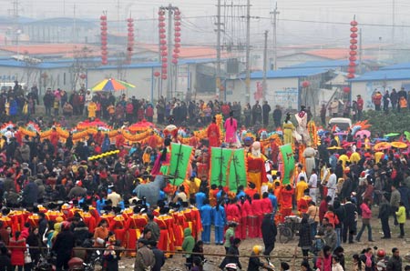 Performers in traditional Chinese dress play in the temporary housing area for May 12 earthquake survivors during the 2009 Lunar New Year Paintings Festival held in Mianzhu, one of the worst-hit towns during the May 12 quake in southwestern Chinese province of Sichuan, Jan. 15, 2009.[Chen Xie/Xinhua] 