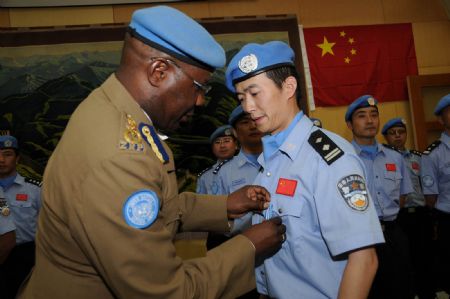 Clement Munoriarwa (L), commissioner of UN peacekeeping mission police forces, presents the 'United Nations Medal' for Chinese peacekeeping policemen at the Chinese embassy to Sudan in Khartoum on Jan. 15, 2009. [Xinhua] 