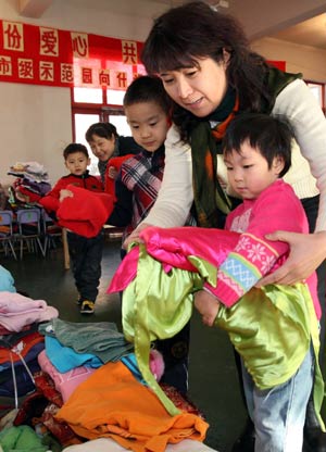 Kids and their teacher in kindergarten donate clothes during a charity activity held at Beijing No.1 Kindergarten in Beijing, Jan. 15, 2009. Kids and teachers from 7 kindergartens in Beijing Wednesday donated more than 2600 winter clothes to the 2 kindergartens in the earthquake-hit areas in southwest China's Sichuan Province. [Xinhua]