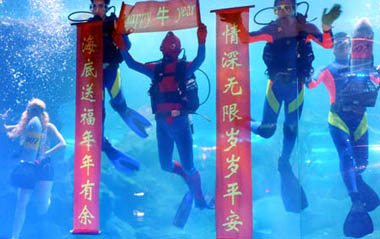 Divers pay a New Year call underwater in Qingdao, a coastal city in east China's Shandong Province, Jan. 15, 2009. As the Spring Festival draws near, Qingdao Underwater World has arranged a series of programs with folk customs for the celebrations, providing the tourists New Year blessings.[Xinhua]