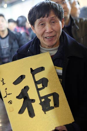 Wang Wanlin, who has helped more than 300 waifs, shows a calligraphy work of 'fu', meaning 'good wishes', during a calligraphy activity held in Hangzhou, capital of east China's Zhejiang Province, Jan. 15, 2009, to greet the Chinese lunar New Year starting from Jan. 26. [Cheng Ruixin/Xinhua]