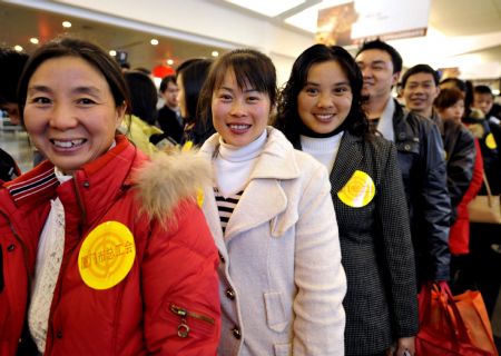 Rural immigrants from the earthquake-hit region in Sichuan Province queue to check in at the Gaoqi Airport in Xiamen, southeast China's Fujian Province, on Jan. 15, 2009. A total of 119 advanced individuals of Sichuan rural immigrants flew home for free with the charter plane of the Xianmen Trade Union on Thursday. [Xinhua]