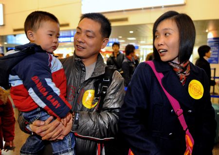  Rural immigrant Wang Qiang (C) from the earthquake-hit region in Sichuan Province waits for boarding with his wife and son at the Gaoqi Airport in Xiamen, southeast China's Fujian Province, on Jan. 15, 2009. [Xinhua]