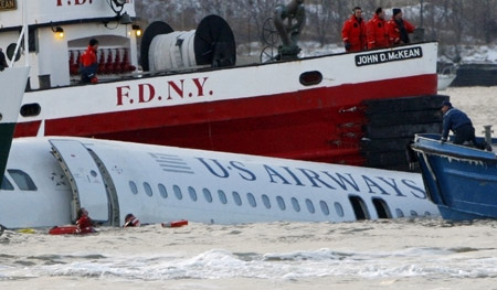  Divers are seen in the water as a US Airways Airbus A320 airliner floats down the Hudson River between Manhattan and New Jersey (back) after making an emergency landing in the river after taking off from New York's LaGuardia Airport, January 15, 2009. A US Airways jet with more than 150 people on board came down into the frigid Hudson River off Manhattan after apparently hitting a flock of geese on Thursday and officials said everyone was rescued. [Xinhua/Reuters]