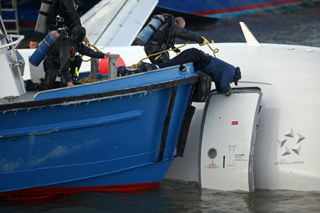 Emergency personnel search for more passengers after a U.S. Airways plane landed in the Hudson River in New York January 15, 2009. A US Airways jet with more than 150 people on board came down into the frigid Hudson River off Manhattan after apparently hitting a flock of geese on Thursday and officials said everyone was rescued. [Xinhua/Reuters]