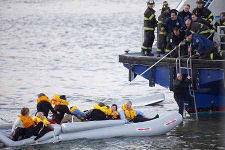 Passengers are rescued after a U.S. Airways plane landed in the Hudson River in New York January 15, 2009. A US Airways jet with more than 150 people on board came down into the frigid Hudson River off Manhattan after apparently hitting a flock of geese on Thursday and officials said everyone was rescued. [Xinhua/Reuters]