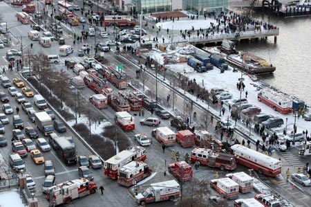 Rescue vehicles wait near the pier after a U.S. Airways plane crashed into the Hudson River in New York, the United States, on Jan. 15, 2009. The U.S. Airways jet on way from New York to Charlotte Thursday crashed into the Hudson River off the west side of Manhattan with more than 150 people on board. [Hou Jun/Xinhua]