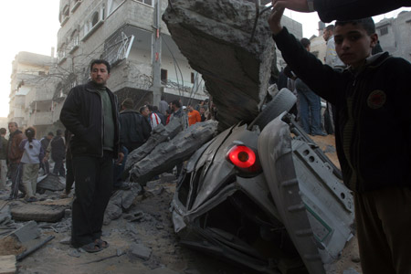 Palestinians gather around the crater caused by an Israeli strike, which hit the house of top Hamas official Said Siam's brother in Gaza City, Jan. 15, 2009. Hamas-appointed interior minister Siam was slain along with his brother and son on Jan. 15 in an Israeli air strike on the brother's house in the north of Gaza City, Hamas said, as it vowed to avenge his death.[Xinhua]