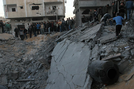 Palestinians gather around the crater caused by an Israeli strike, which hit the house of top Hamas official Said Siam's brother in Gaza City,[Xinhua] 