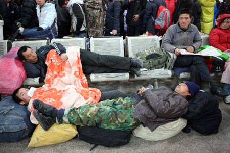 Migrant workers rest as they wait for their train back home at the Beijing West Railway Station in Beijing Jan. 15, 2009. China's annual Spring Festival pessenger rush is getting started these days as the Spring Festival comes close. 