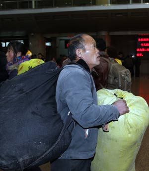 A migrant worker checks the timetable at the Beijing West Railway Station in Beijing Jan. 15, 2009. China's annual Spring Festival pessenger rush is getting started these days as the Spring Festival comes close.