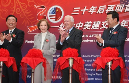 Former U.S. President Jimmy Carter (2nd R) applauds after cutting the ribbon for a picture exhibition marking the 30th anniversary of the establishment of China-U.S. diplomatic ties in Shanghai, east China, Jan. 16, 2009. 