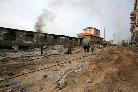 Palestinian people walk past a destroyed area after Israeli military operations in the Tal al Hawa area of Gaza City, Jan. 16, 2009. The death toll in Gaza has risen to more than 1140 since the beginning of the Israeli massive attack on Gaza on Dec. 27, 2008, with about 5150 wounded, Gaza emergency chief Mo'aweya Hassanein said on Friday. (Xinhua/Wissam Nassar)