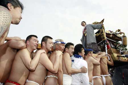 A 20-year-old girl stands on a portable shrine carried by people along the seashore during a purification ceremony at the Katase-Enoshima beach in Fujisawa of Kanagawa prefecture Jan. 18, 2009. The annual ceremony celebrates the coming-of-age for young people. 