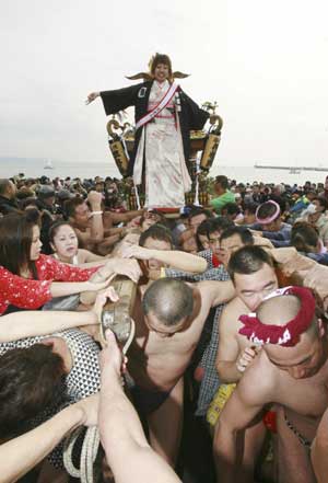 A 20-year-old girl stands on a portable shrine carried by people along the seashore during a purification ceremony at the Katase-Enoshima beach in Fujisawa of Kanagawa prefecture Jan. 18, 2009. The annual ceremony celebrates the coming-of-age for young people. 