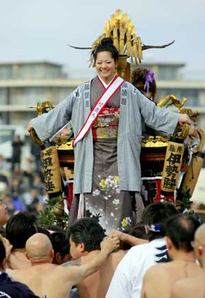 A 20-year-old girl stands on a portable shrine carried by people along the seashore during a purification ceremony at the Katase-Enoshima beach in Fujisawa of Kanagawa prefecture Jan. 18, 2009. The annual ceremony celebrates the coming-of-age for young people. 