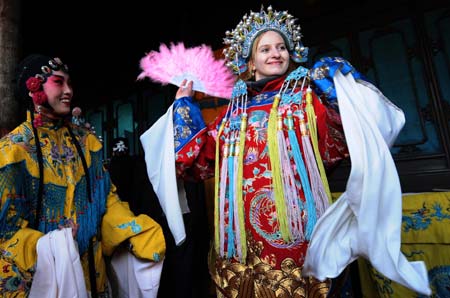 A foreign tourist tries playing Jin Opera that is popular in north China's Shanxi Province in Pingyao, Shanxi, Jan. 17, 2009. The time-honoured Pingyao city listed among the UNESCO World Cultural Heritages prepares for the approaching Spring Festival with traditional celebrations. 