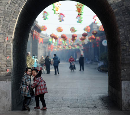 Two little girls play in street decorated with lanterns in Pingyao, north China's Shanxi Province, Jan. 17, 2009. The time-honoured Pingyao city listed among the UNESCO World Cultural Heritages prepares for the approaching Spring Festival with traditional celebrations. 