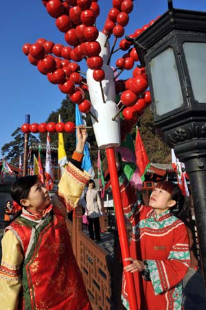 Workers in ancient Chinese dress decorate the street with mock Tanghulu, a Beijing's traditional snack made of sugarcoated haws and other fruit on a stick, for the royal temple fair in the Summer Palace in Beijing, Jan. 18, 2009. Visiting temple fairs, or 'Miaohui' in Chinese, is one of the most important traditional activities during the Spring Festival holidays. 