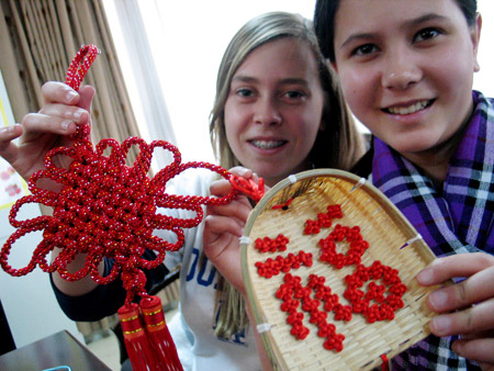 Two New Zealand students display Chinese knots in Shandong Normal University in Jinan, capital of east China's Shandong Province, Jan. 19, 2009. [Xinhua] 