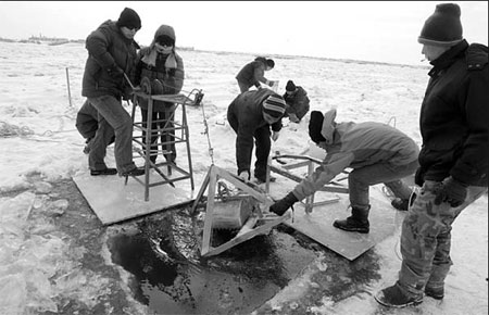 Scientists from the Chinese Research Academy of Environmental Sciences collect water and sand samples along the Fujin section of the Songhua River in Heilongjiang province. [Deng Jia/China Daily] 
