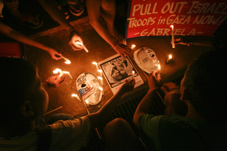 Filipino women and children light candles as they gathered in a park in Quezon City, north of Manila, Jan. 19, 2009 to express their demand for justice to the Palestinian women and children who comprise a big number of those killed and injured by Israeli attacks on Gaza. 