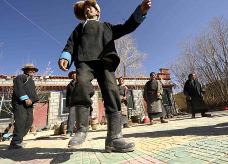 Villagers of the Tibetan ethnic group dance to celebrate the setting of the Serfs Emancipation Day in Banjorihunbo Village of southwest China&apos;s Tibet Autonomous Region, Jan. 19, 2009.
