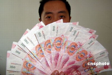 A policeman displays confiscated fake banknotes in East China's Wenzhou city, Zhejiang province, Jan 13, 2009. China's Ministry of Public Security launched Tuesday a special campaign against fake banknote crimes after high-quality fake notes were found ahead of the shopping-spree Spring Festival holiday.[chinanews.com] 