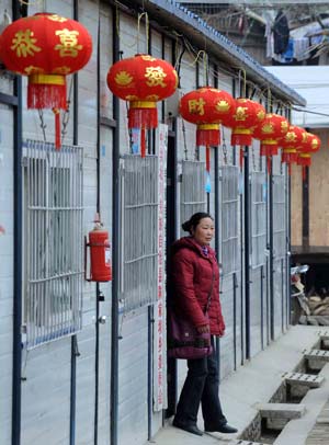 A woman walks out of a temporary dwelling decorated with red lanterns in Chenjiaba Township of Beichuan County, southwest China's Sichuan Province, Jan. 20, 2009, before the Chinese lunar New Year starts from Jan. 26. Beichuan was one of the areas hit most seriously by the May 12 earthquake last year. 