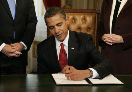 With his left hand, Barack Obama signs his first act, a proclamation, after being sworn in as the 44th President of the United States during the inaugural ceremony in Washington Jan. 20, 2009. 