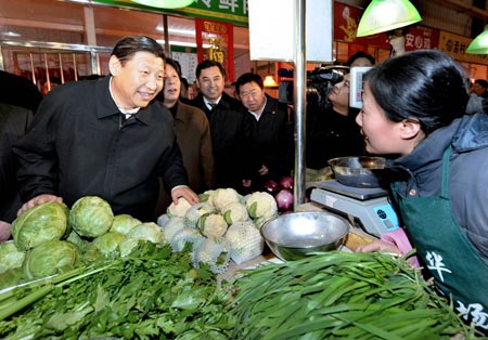 Chinese Vice President Xi Jinping (1st L), also member of the Standing Committee of the Political Bureau of the Communist Party of China (CPC) Central Committee, talks to a vegetable vendor in a market during his visit to Tianjin Municipality Jan. 18, 2009.