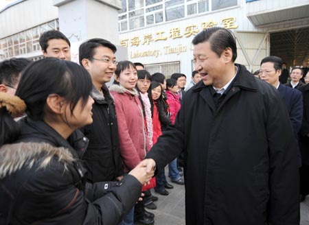 Chinese Vice President Xi Jinping (1st R, front), also member of the Standing Committee of the Political Bureau of the Communist Party of China (CPC) Central Committee, talks to teachers and students on campus of Tianjin University during his visit to Tianjin Municipality Jan. 18, 2009. 