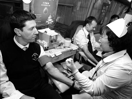 Citibank employees Ian Lacy (left) and Tim Fleming give blood yesterday in Shanghai. Gao Erqiang