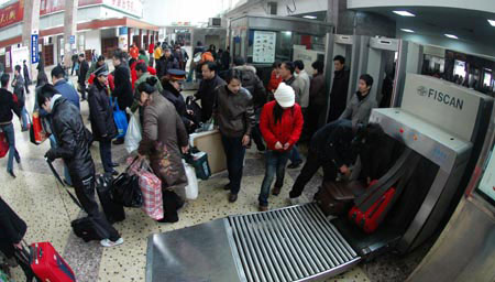 Passengers go through security check at the entrance of the Changsha Railway Station in Changsha, capital of central-south China's Hunan Province, Jan. 21, 2009. With the approach of the Chinese lunar New Year, Hunan railways have transported over 1 million passengers since the formal start of the annual Spring Festival travel peak on Jan. 11. [Photo: Xinhua] 