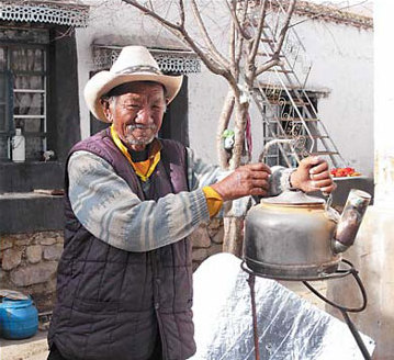 Tibet resident Kerong boils a pot of water via a solar energy facility in his courtyard last week. [China Daily]