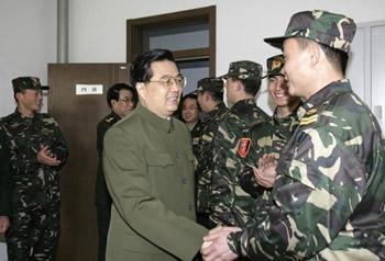 Chinese President Hu Jintao, who is also General Secretary of the Communist Party of China (CPC) Central Committee and chairman of the Central Military Commission (CMC), talks with a soldier of Beijing Military Area Command in Beijing, capital of China, Jan. 21, 2009. [Wang Jianmin/Xinhua]