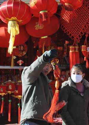 A man picks a New Year mascot in Lhasa, capital of southwest China's Tibet Autonomous Region, Jan. 21, 2009. New Year's decorations become popular in Lhasa as the Chinese lunar New Year is approaching. The Chinese Spring Festival, or lunar New Year, falls on Jan. 26 this year.